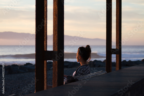 Young woman watching waves during sunset © Hans