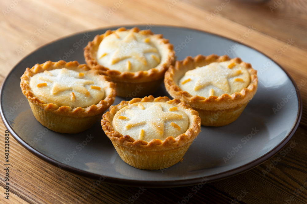 Mince pies with raisins and cinnamon on wooden background Mince pies with raisins and cinnamon on wooden background