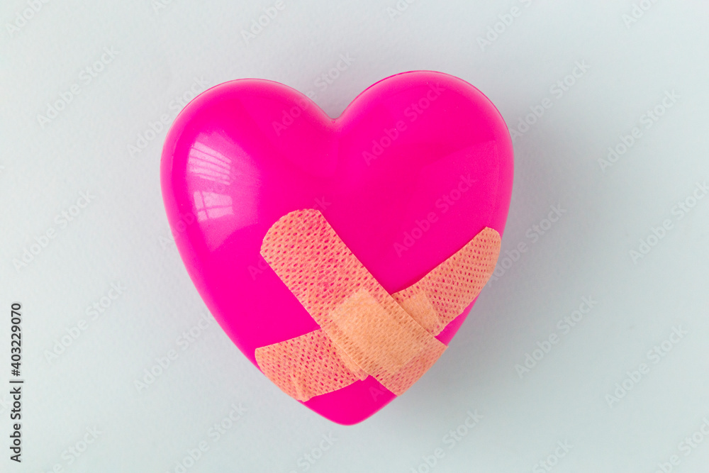 Broken heart patched with a patch. Healing love concept Broken heart patched with a patch. Healing love concept