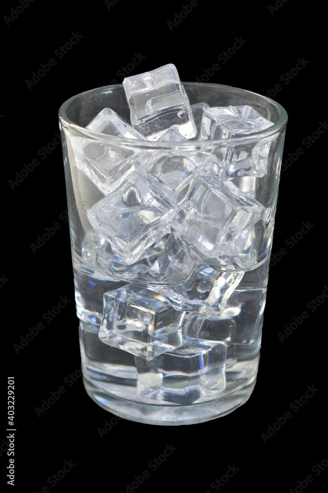 Transparent ice cubes are in a transparent glass on a black background. Transparent ice cubes are in a transparent glass on a black background.