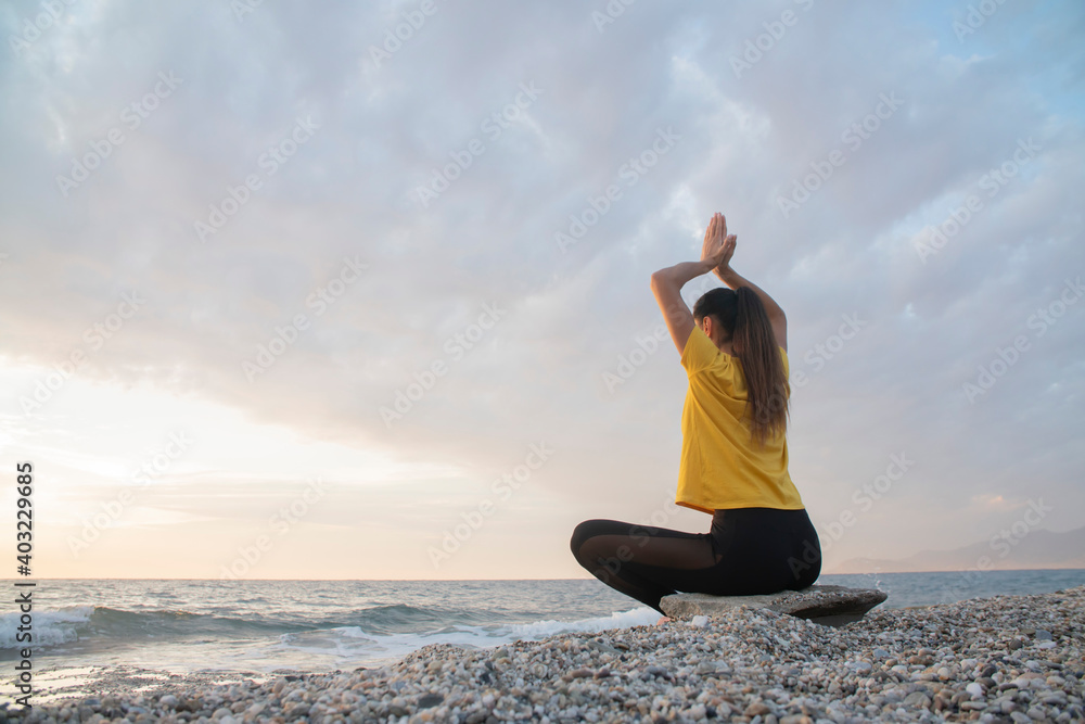 Yoga woman in Lotus position practicing yoga and meditation. outdoors on the evening ocean Yoga woman in Lotus position practicing yoga and meditation. outdoors on the evening ocean