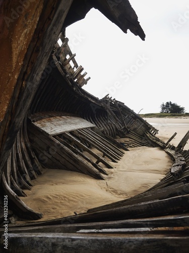 Stranded broken wooden shipwrecks on fishing boat naval graveyard marine cemetery in Magouer Etel river Brittany France photo