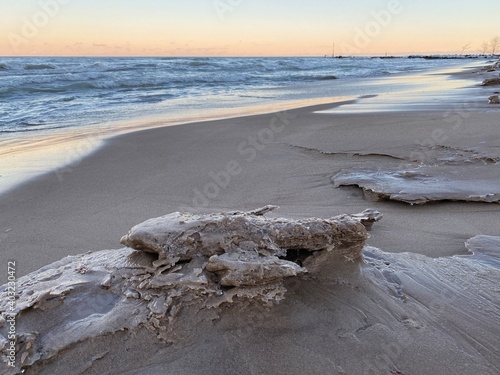 Winter sunset at Gillson Beach on Lake Michigan's Illinois shore. Waves and frigid temps left piles of sand and ice along the beach. photo