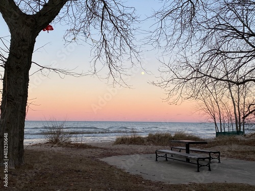 Winter sunset at Gillson Beach on Lake Michigan's Illinois shore. A full moon is rising in the distance.