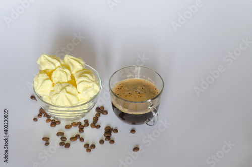 A cup of coffee  a delicate meringue dessert and coffee beans on a light background