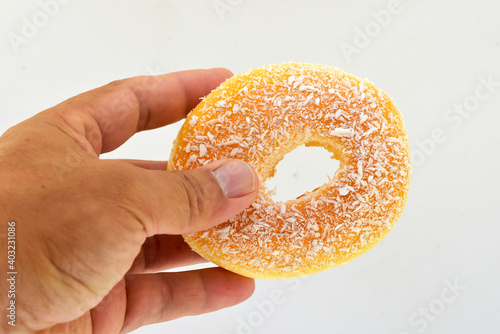 The large, yellow donut looks delicious in the customer's left hand. 