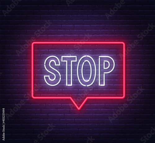 Neon stop sign in a frame on brick wall background .
