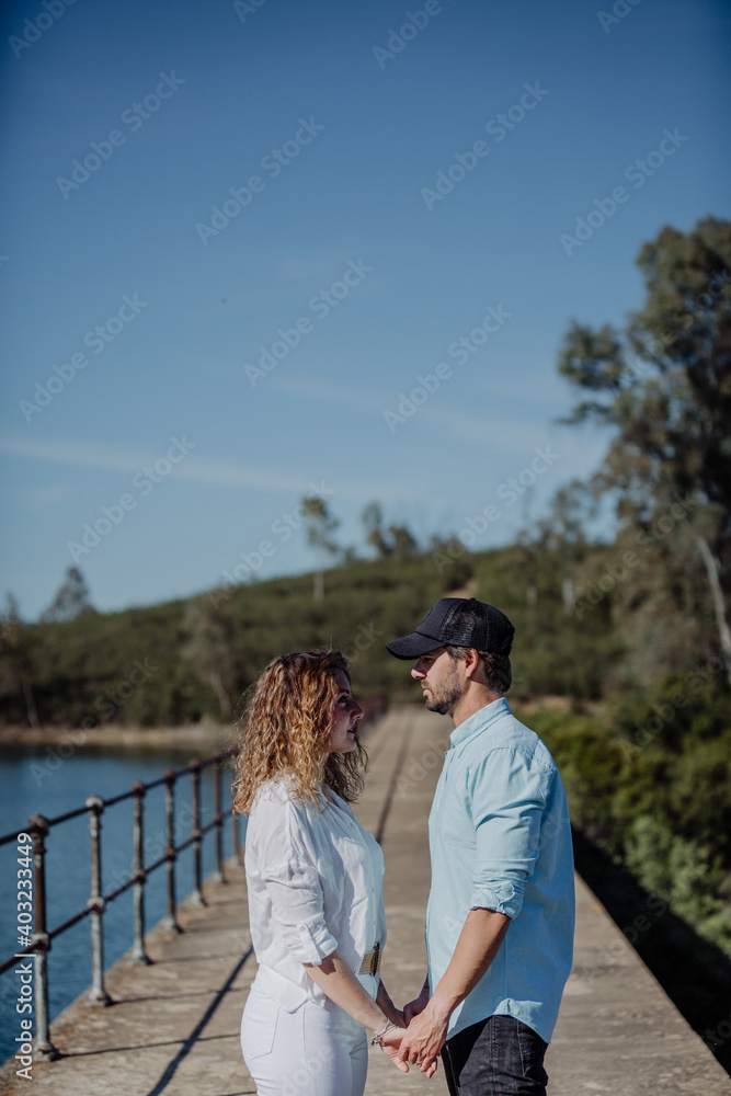 Young couple in front of each other looking at each other.Springtime. He with a cap, space text. concept love. Young couple in front of each other looking at each other.Springtime. He with a cap, space text. concept love.