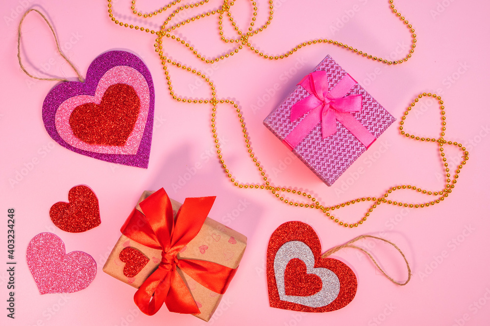 Valentine's Day or birthday presents. Valentine's Day gifts with a red paper heart on a pink background. Top view. Pink background.