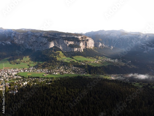 View towards swiss alpine mountain village town Flims Laax from Caumasee in Grisons Graubunden Switzerland Europe photo