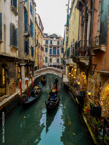 Gondolas and festive Christmas decorated shops in a quiet side canal in Venice © Julie