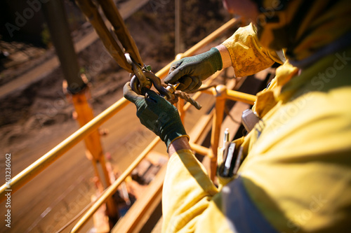 Bild auf Leinwand Safe work practices top view of rigger crane high risk worker wearing a safety glove fastening pin into D- shackle 4