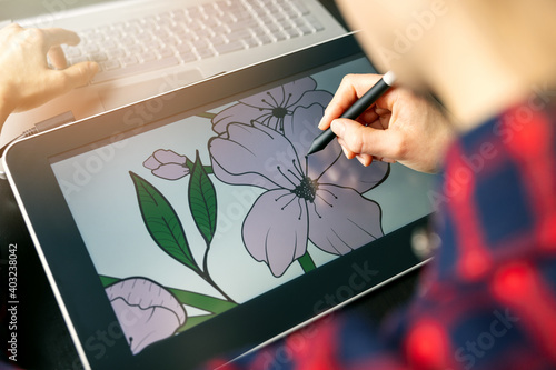 illustrator graphic designer draw flower illustration on drawing tablet. digital artist at work photo