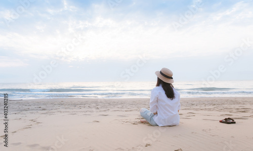 Travel woman sitting on the beach alone