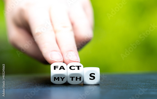 Hand turns dice and changes the word myths to facts.