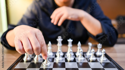 Businessman hand or chess player moving chess piece on chessboard game defeating the king. Management strategy and leadership in competition. Achievement concept