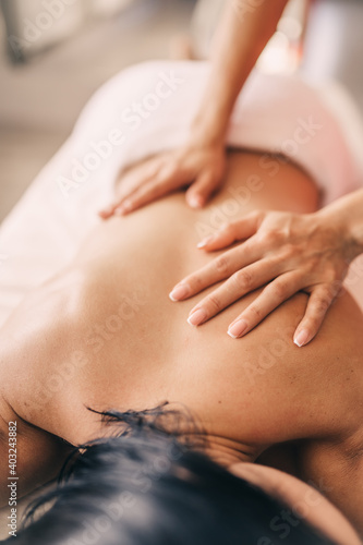 Young woman have medical recovery massage. Close-up of woman relaxing during back and neck massage