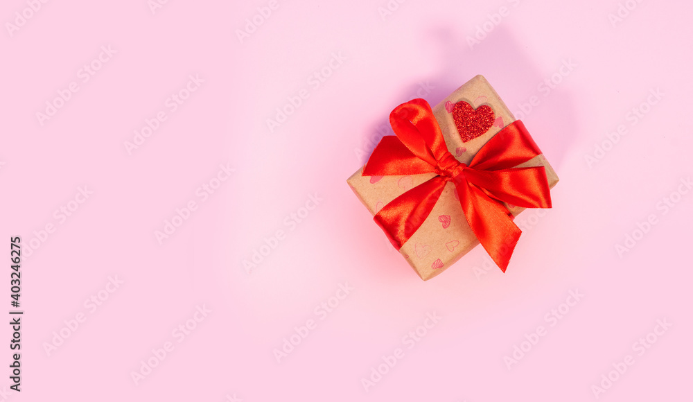 Valentine's Day or birthday presents. Valentine's Day gifts with a red paper heart and gift box with red ribbon on a pink background. Top view. Handicraft gifts. Valentine's Day or birthday presents. Valentine's Day gifts with a red paper heart and gift box with red ribbon on a pink background. Top view. Handicraft gifts.