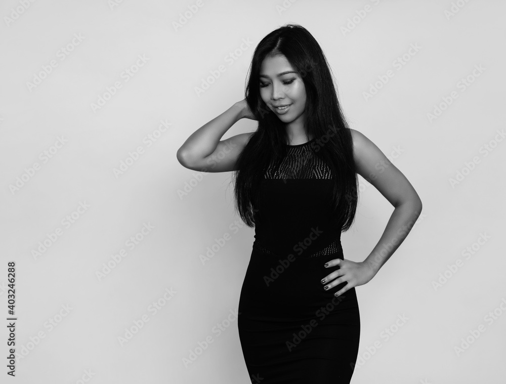 Beautiful asian woman with long black hair posing in dress on grey background Beautiful asian woman with long black hair posing in dress on grey background