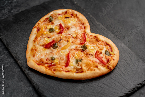 heart shaped pizza for valentine's day on stone background