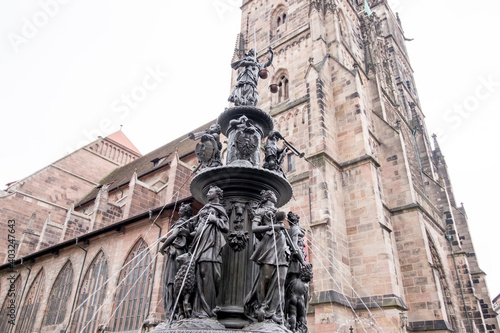 Statues in Nurnberg city center. There are lots of mothers who are flushing water from their breasts. There are children on second floor and they are playing musical instruments. And there is a woman  photo