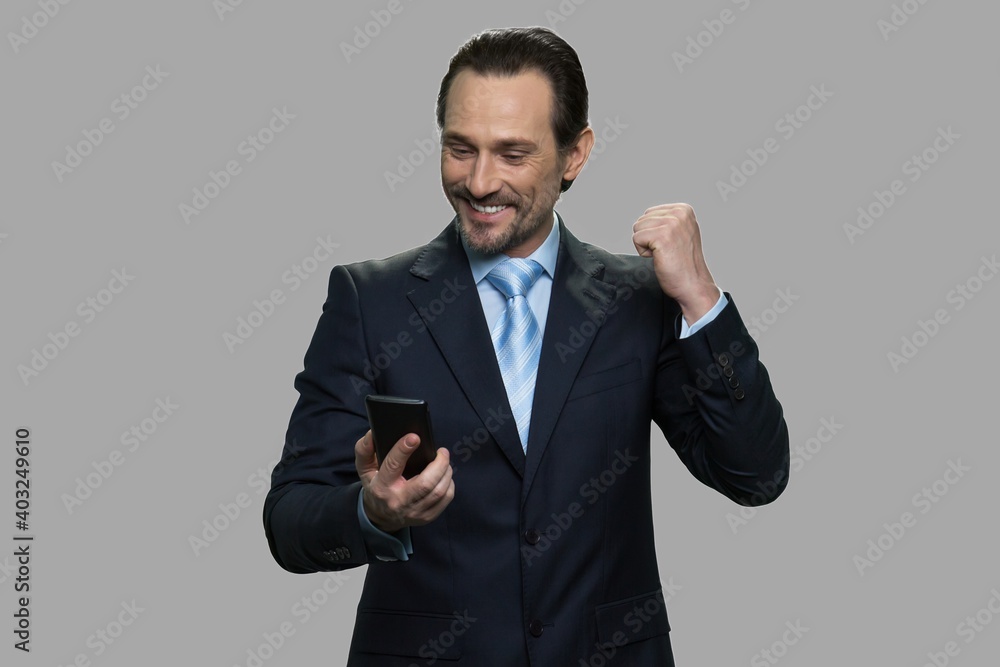 Businessman celebrating success while reading message on smartphone. Business sucess and achievement. Businessman celebrating success while reading message on smartphone. Business sucess and achievement.