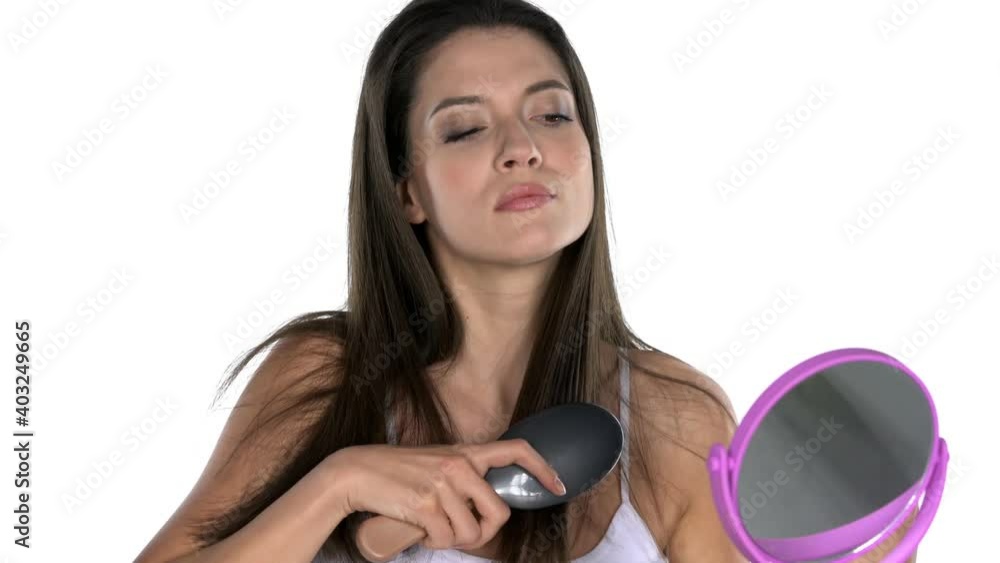 a young beautiful woman has a problem combing her hair on a white background a young beautiful woman has a problem combing her hair on a white background