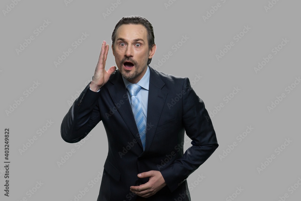 Businessman with shocked facial expression. Amazed scared businessman against gray background. Businessman with shocked facial expression. Amazed scared businessman against gray background.