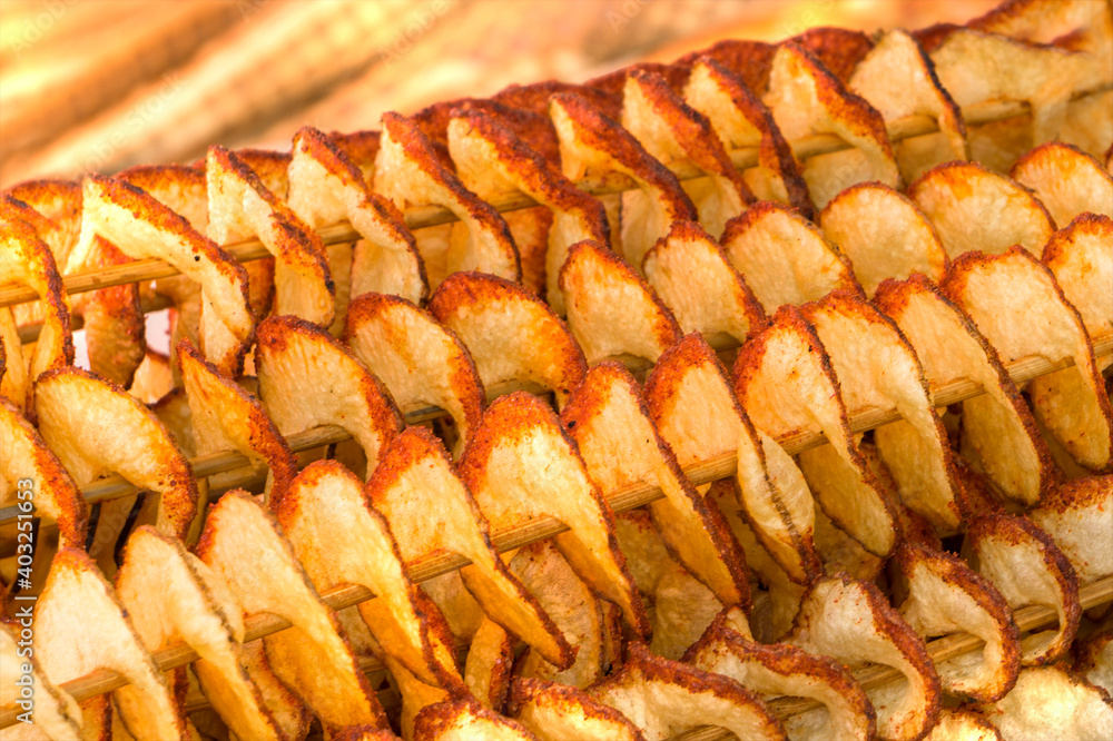 Fried potatoes on wooden sticks. Deep-fried dishes. Close the background. Fried potatoes on wooden sticks. Deep-fried dishes. Close the background.