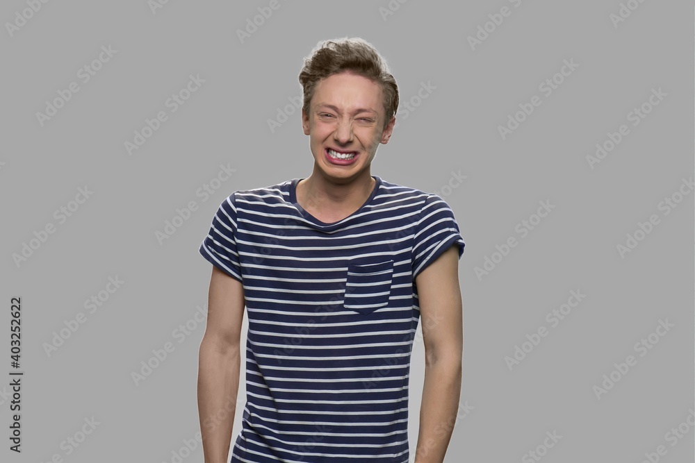 Emotional teenage boy on gray background. Portrait of nervous expressive teen boy. Emotions, expression and feelings concept. Emotional teenage boy on gray background. Portrait of nervous expressive teen boy. Emotions, expression and feelings concept.