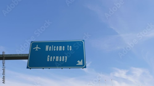 plane flying over welcome to germany  billboard road sign photo