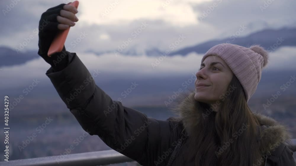 Woman taking selfie on balcony of high-rise Woman taking selfie on balcony of high-rise