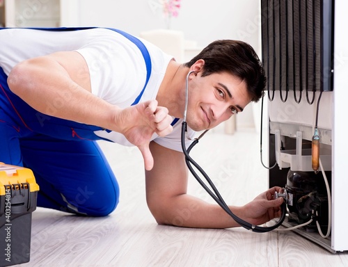 Repairman contractor repairing fridge in DIY concept