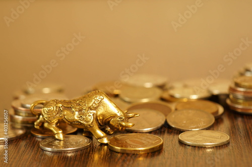 Metal figurine of a bull. There's a pile of coins nearby.