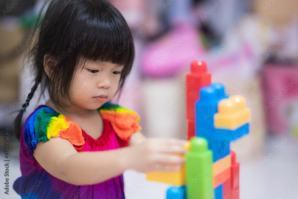 Cute little girl playing plastic block. Children play plastic puzzles, strengthen imagination and hand muscles. Kid are 3 years old. Cute little girl playing plastic block. Children play plastic puzzles, strengthen imagination and hand muscles. Kid are 3 years old.