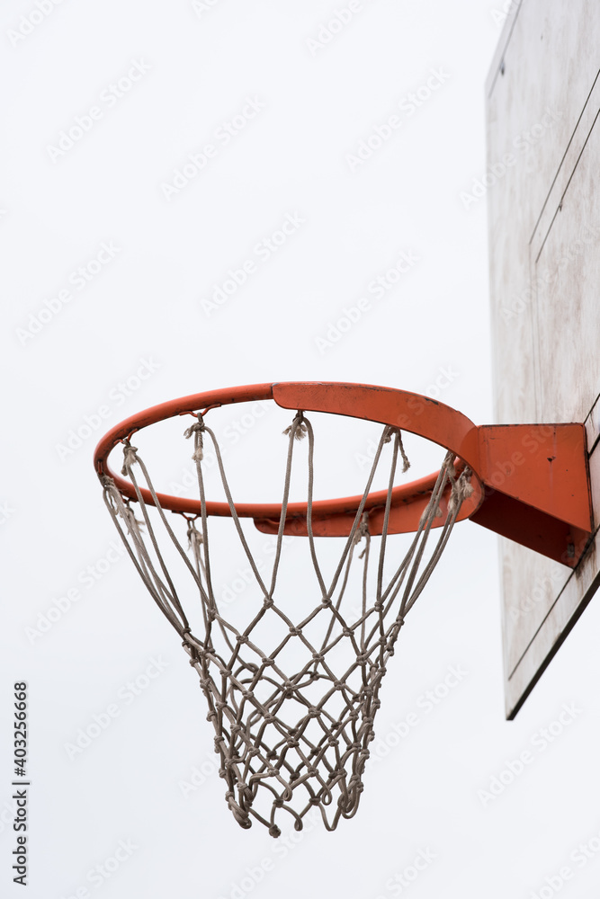 Basketball hoop, basket with white net and white blown up sky in background - obrazy, fototapety, plakaty 
