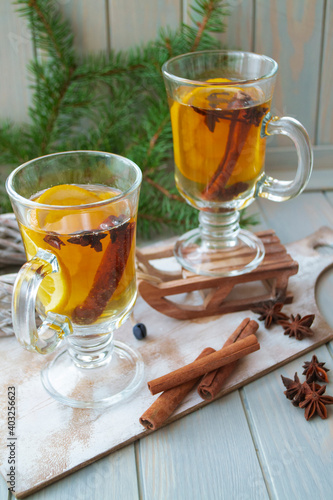 Hot tea in glass with spices on a wooden background. Still life, seasonal and holidays concept