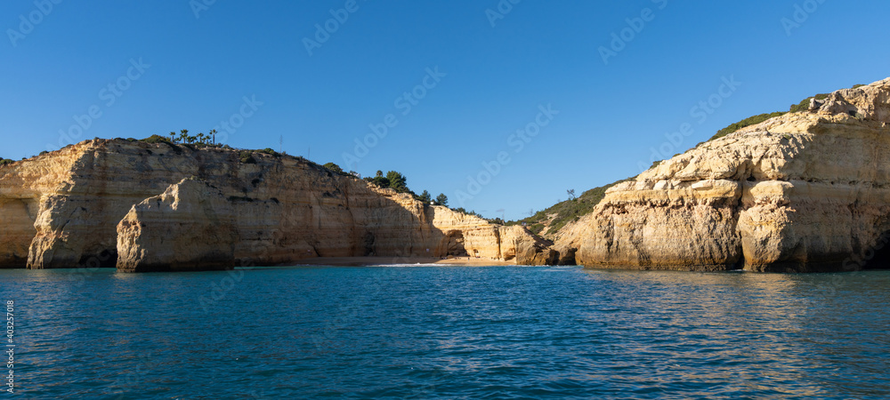rock and cliff coast under a brigh blue sky with sea caves on the Atlantic coast