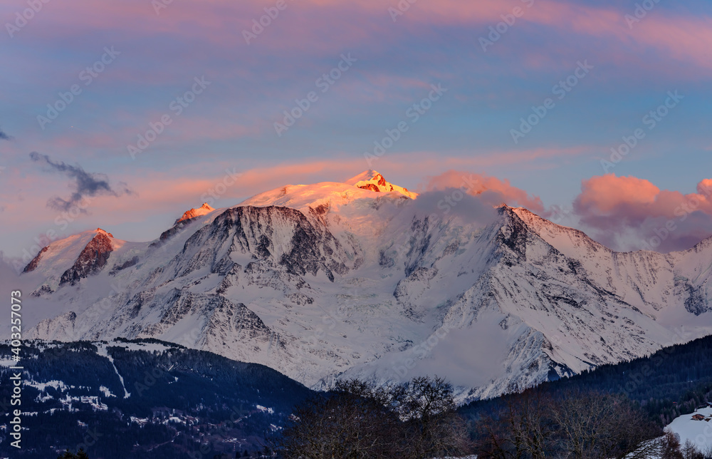 Warm morning clouds over Mont Blanc mountain ridge, the highest mountain in the Alps and Western Europe. Mont Blanc chain seen from the French side. Panorama shot.