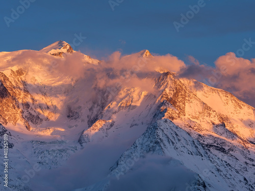 Warm morning clouds over Mont Blanc mountain ridge  the highest mountain in the Alps and Western Europe. Mont Blanc chain seen from the French side. Panorama shot.
