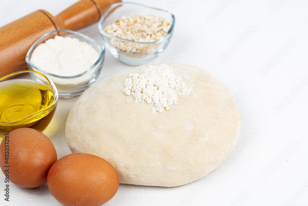 Dough with flour, olive oil, eggs and rolling pin. cooking and baking ingredients
