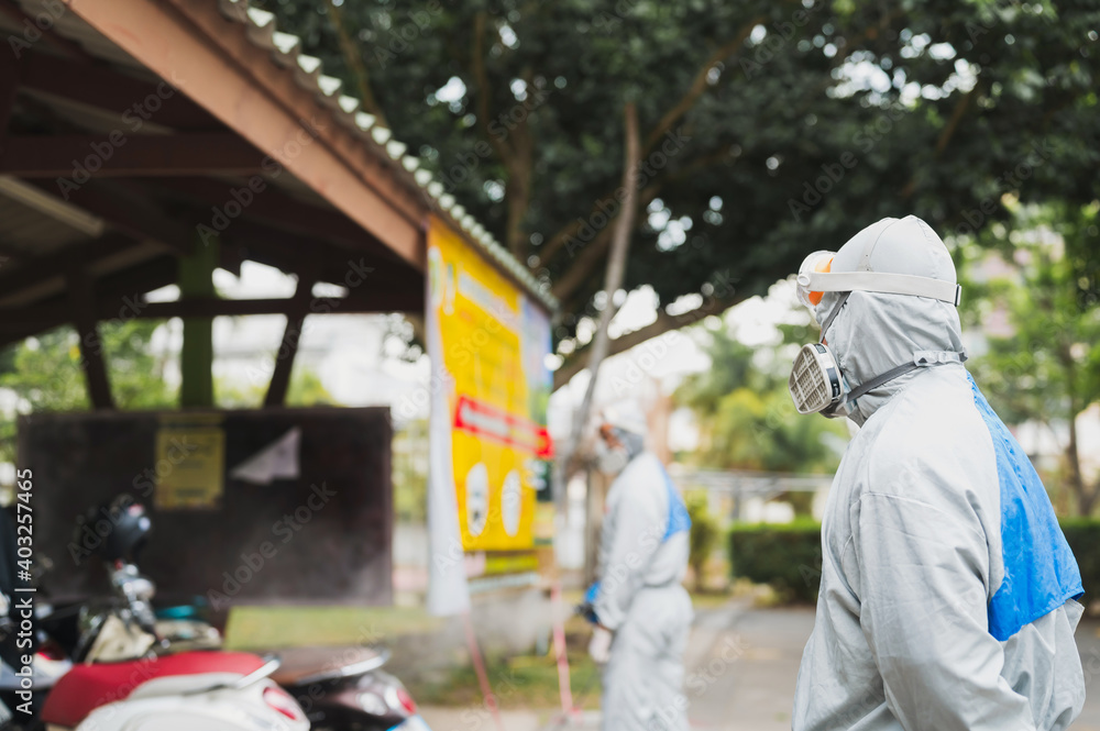 Disinfecting of office to prevent COVID-19, person in white hazmat suit with disinfect Cleaning and sterilizing the not crowded city streets. Disinfecting of office to prevent COVID-19, person in white hazmat suit with disinfect Cleaning and sterilizing the not crowded city streets.