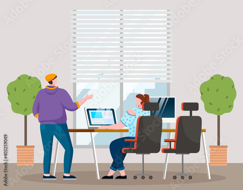 Businesswomen dressed in casual clothes sitting at the table with computer, standing in room and talking. Office meeting and consideration of working affairs. Office workers women in workspace