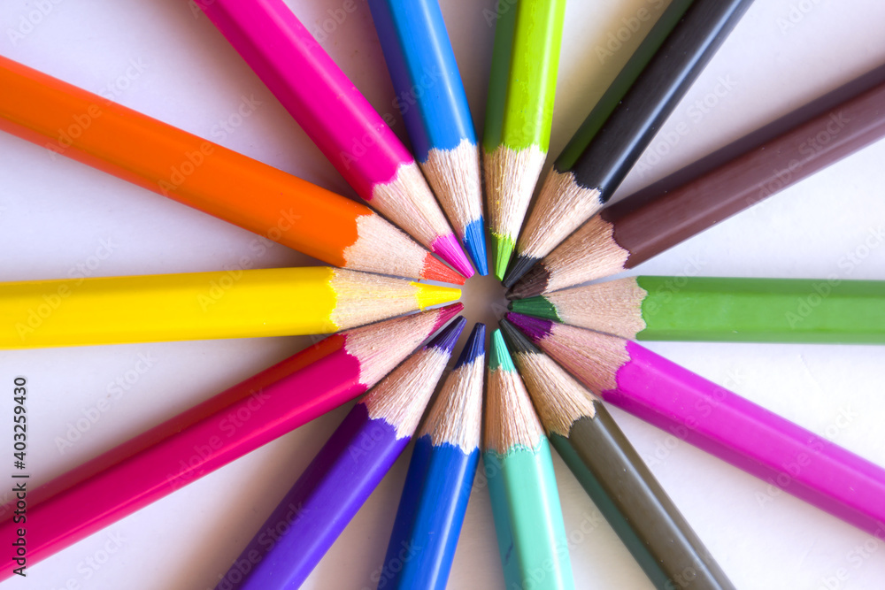 Colored pencils placed in circles on a white background. Colored pencils placed in circles on a white background.