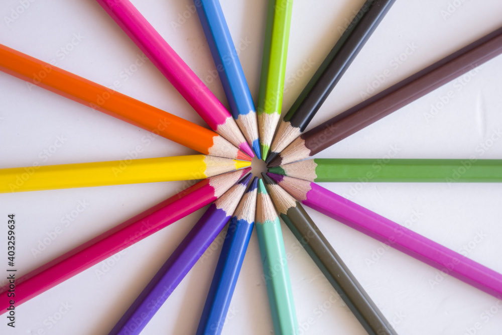 Colored pencils placed in circles on a white background. Colored pencils placed in circles on a white background.