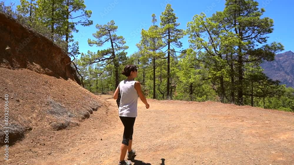 A young woman walking on the La Cumbrecita trekking trail on the island of La Palma next to the Caldera de Taburiente, Canary Islands. Spain A young woman walking on the La Cumbrecita trekking trail on the island of La Palma next to the Caldera de Taburiente, Canary Islands. Spain