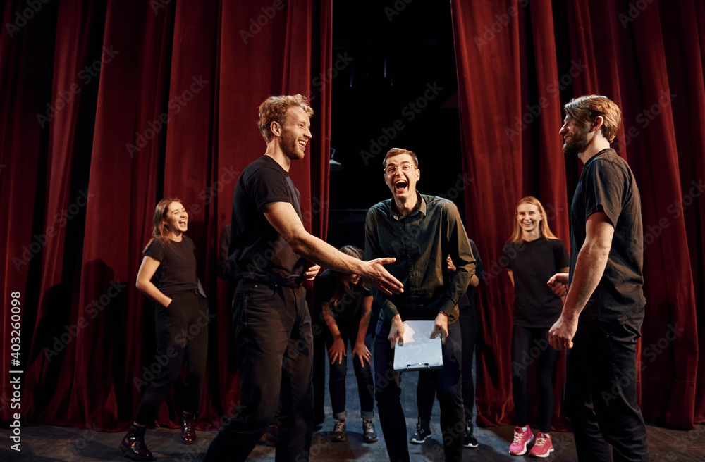 Working together. Group of actors in dark colored clothes on rehearsal in the theater - obrazy, fototapety, plakaty 