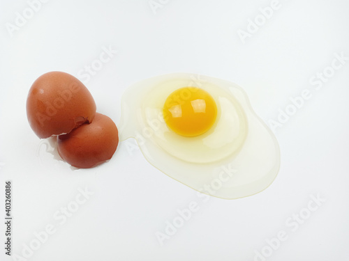 One raw chicken egg with yellow yolk and clear white egg in three layers and broken eggshell in pieces isolated on white background with clipping path. The largest cell in the world.