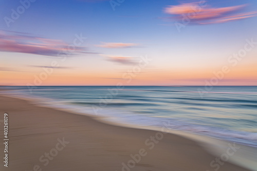 Palm Beach Island beach sunset with slow shutter pan of pink  blue and purple skies with green ocean water