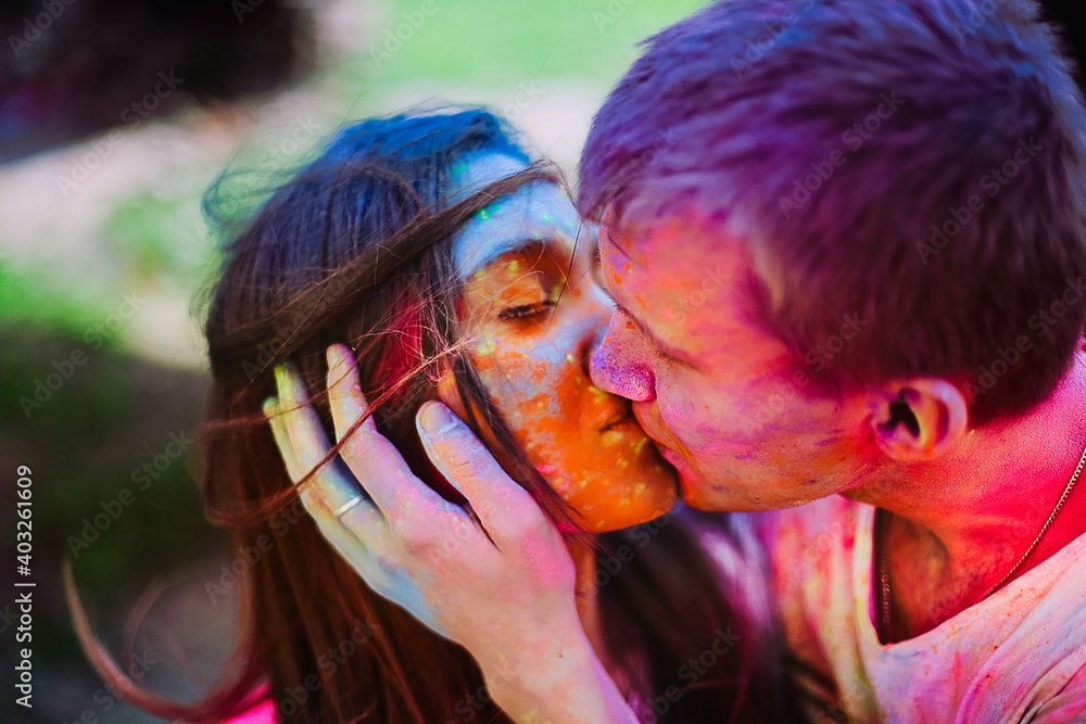 Young woman and man kissing and celebrating holi festival. Portrait of  happy couple in love on holi color festival. Love and hippie lifestyle  concept Stock Photo | Adobe Stock